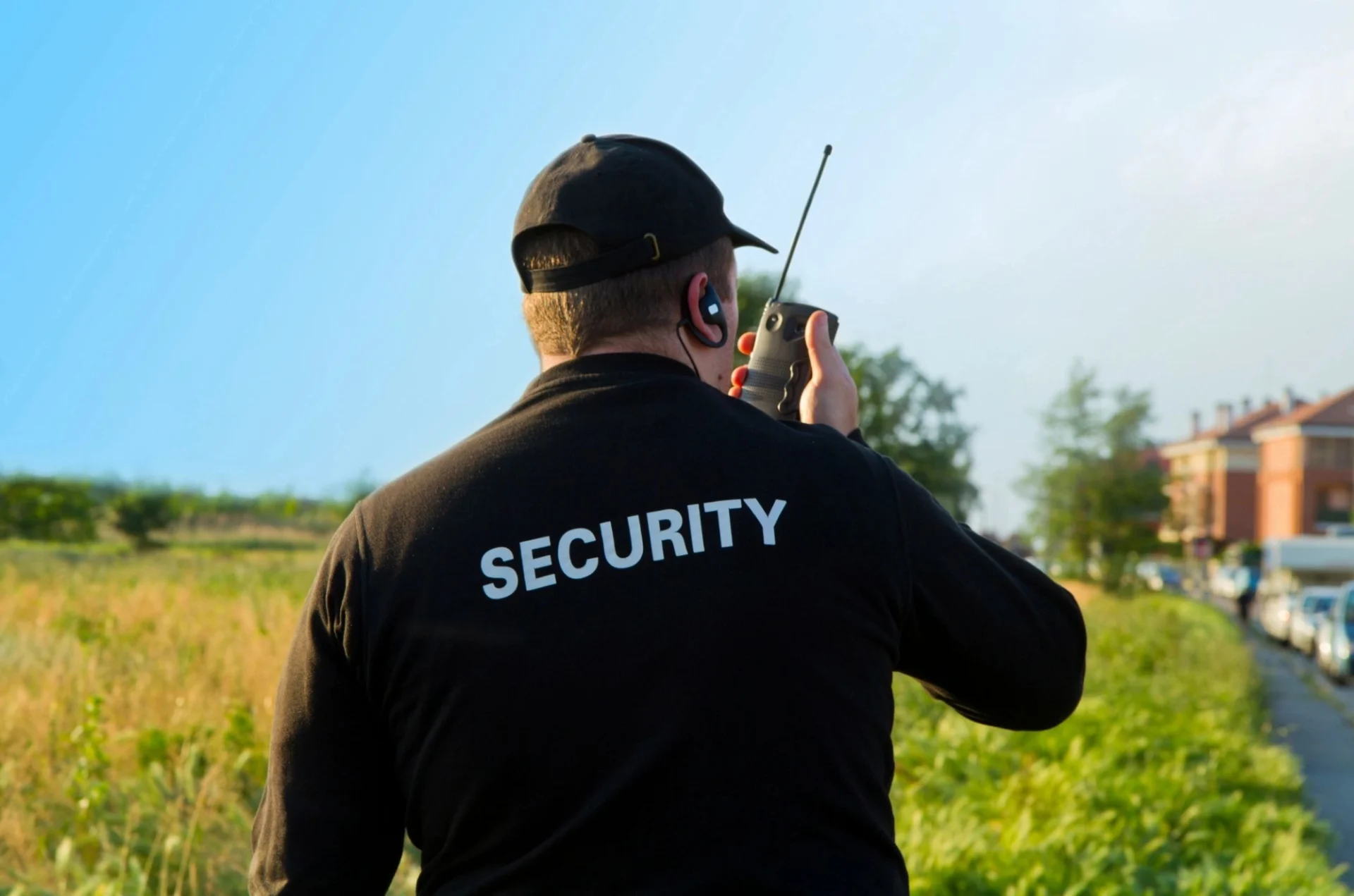 A man in black shirt holding a walkie talkie.